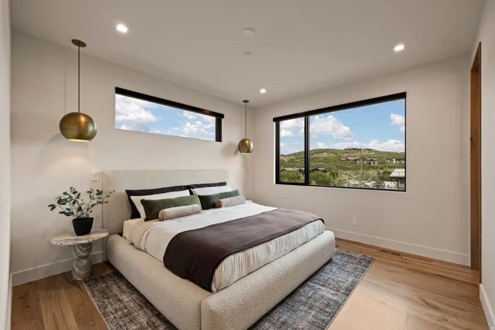 Bedroom featuring hardwood flooring, recessed lighting, and a large picture window