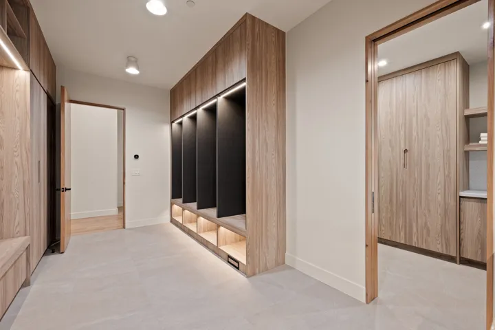 Built-in wood-finish cabinetry featuring open cubbies with integrated lighting, wood-finish flooring, and recessed ceiling lights
