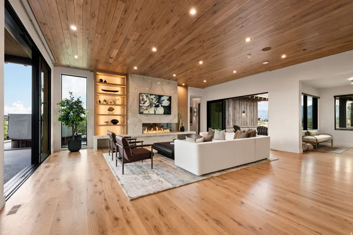 Spacious living area featuring wide plank wood-finish flooring and a matching wood-paneled ceiling with recessed lighting