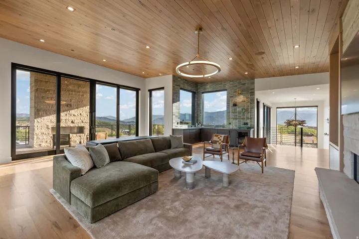 Expansive living area featuring wood-finish flooring and a wood-paneled ceiling with recessed lighting