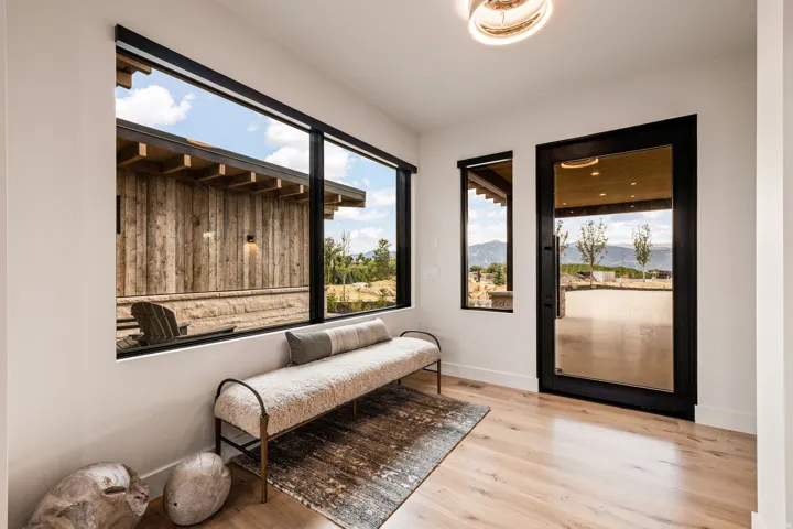 Modern entryway with wood-finish flooring, a full-lite glass entry door, and expansive windows