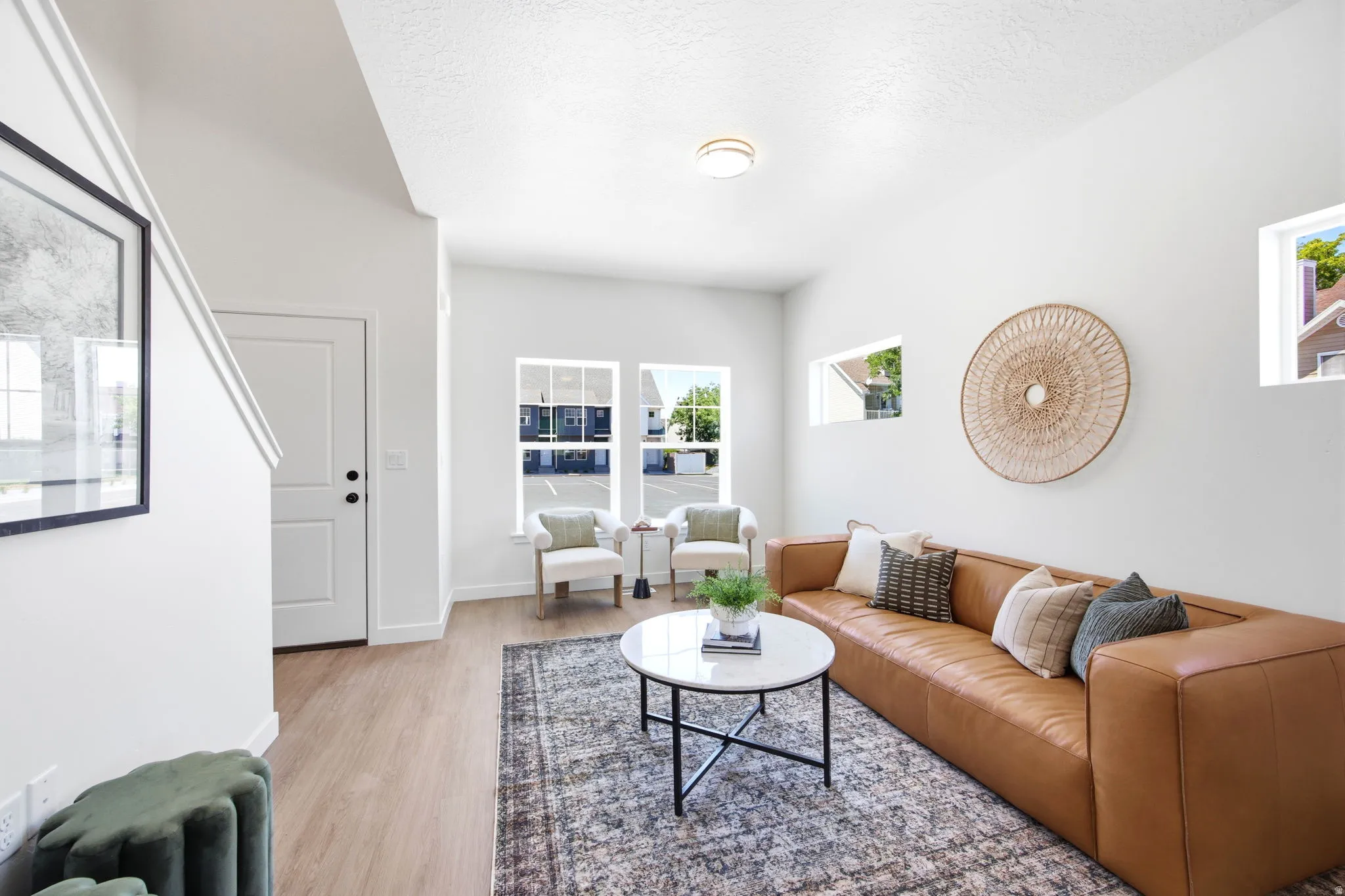 Bright living area featuring wood-finish flooring and multiple windows