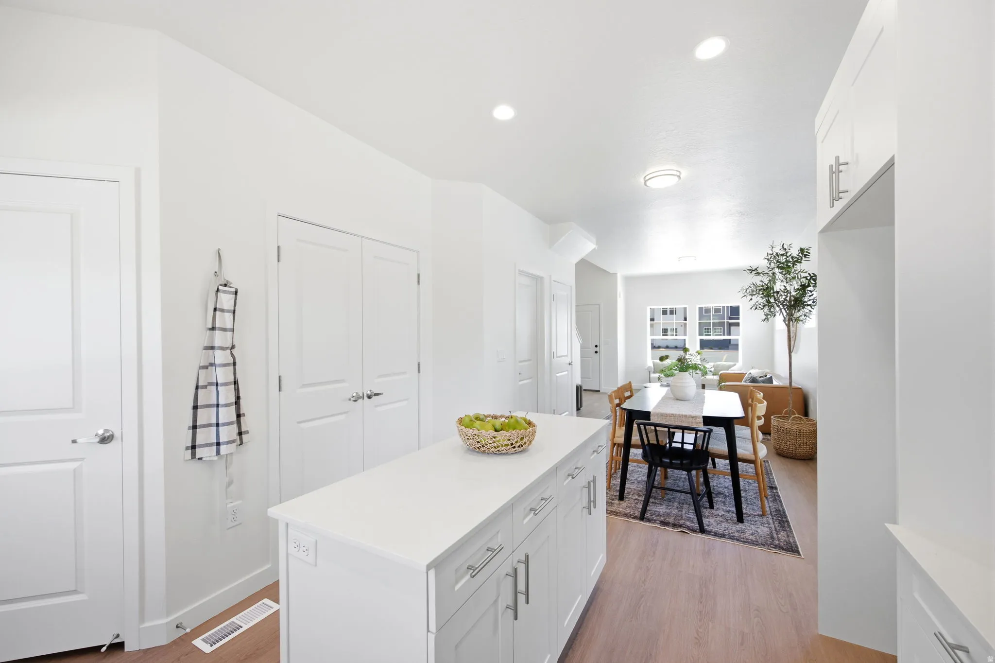 Kitchen island featuring a white countertop and white cabinetry with silver hardware