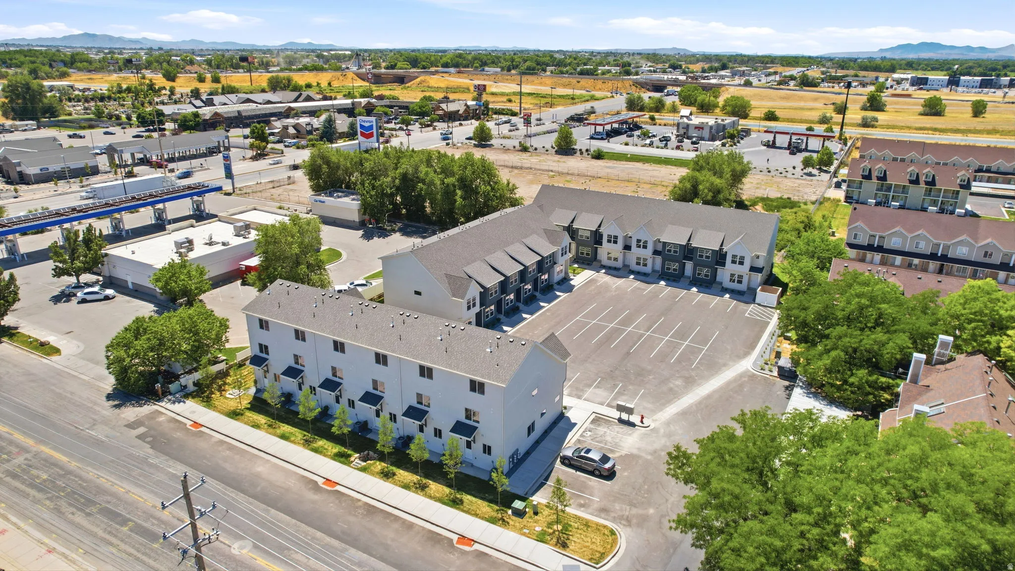 Aerial perspective showcasing two multi-story residential buildings with contemporary facades and dark shingle roofs