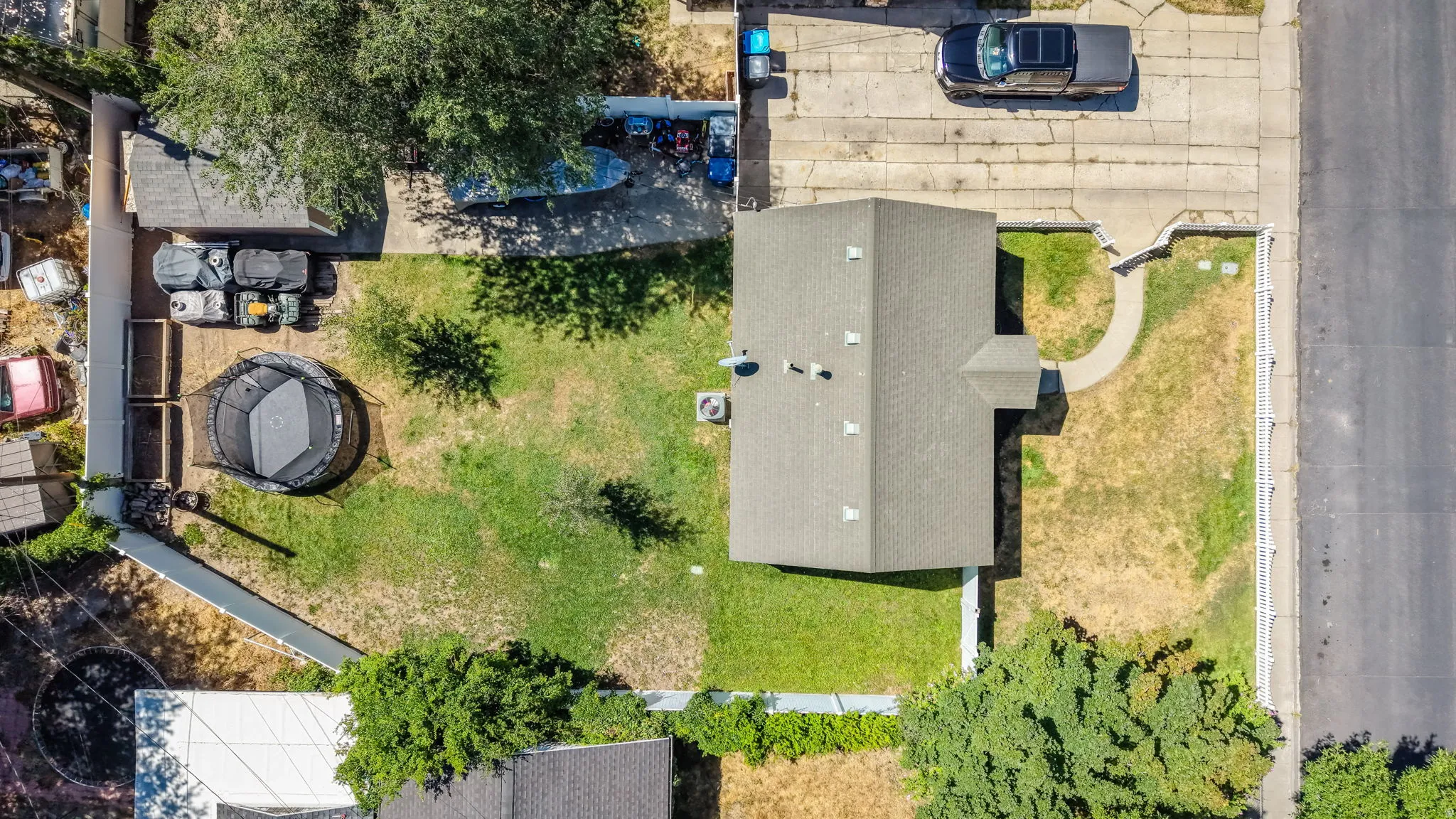 Property exterior featuring a gray shingled roof, a paved driveway, and a concrete sidewalk leading to the front entrance