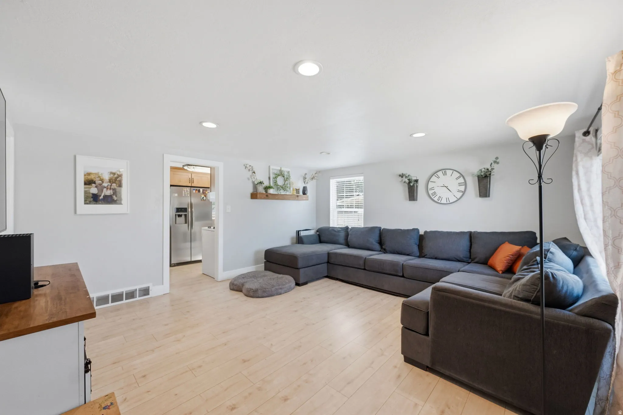 Bright living space featuring light wood-finish flooring, recessed lighting, and light gray wall paint