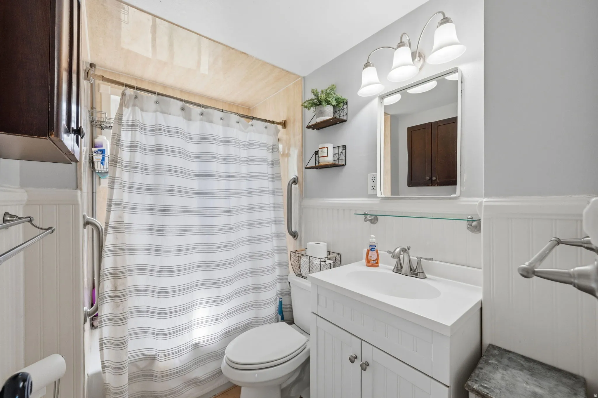 Bathroom featuring a white vanity with integrated sink, chrome faucet, and mirrored medicine cabinet