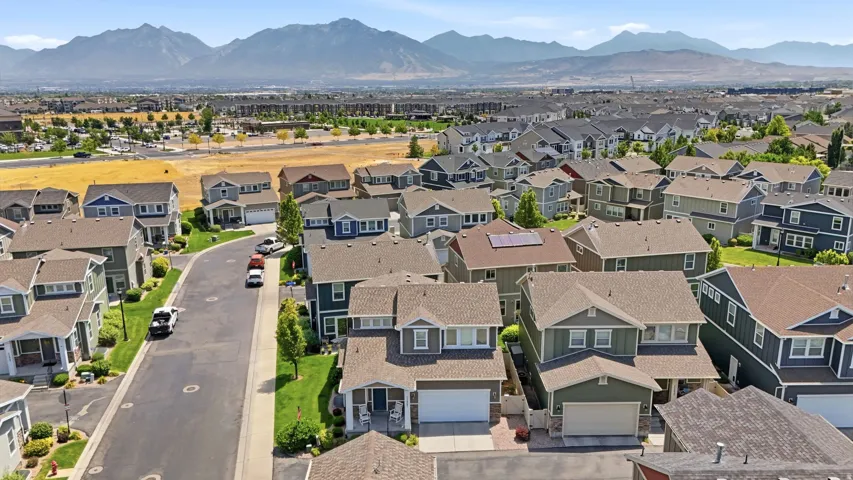 Residential community featuring a variety of two-story homes with attached garages, pitched roofs, and landscaped front yards