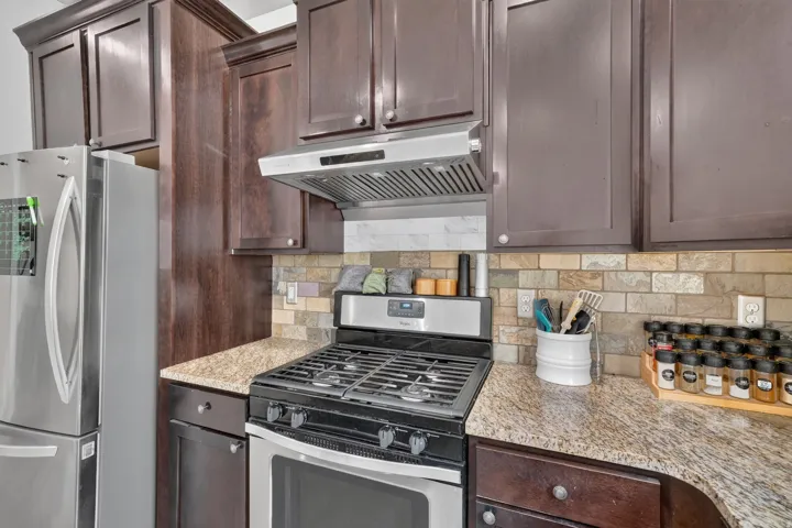 Kitchen showcasing stainless steel appliances, including a gas range and range hood
