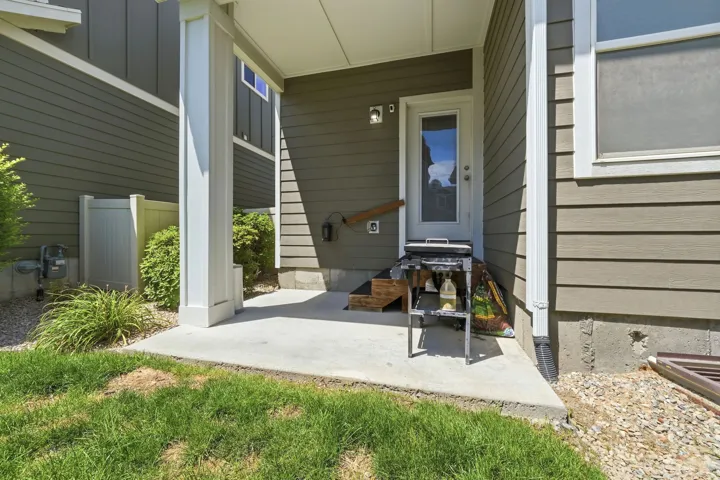 Covered concrete patio with a white support column, leading to an exterior entry door