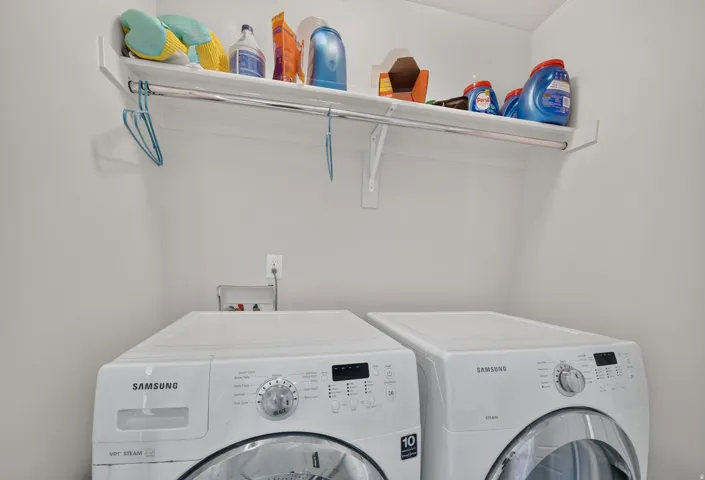 Dedicated laundry area featuring a built-in white shelf with a hanging rod