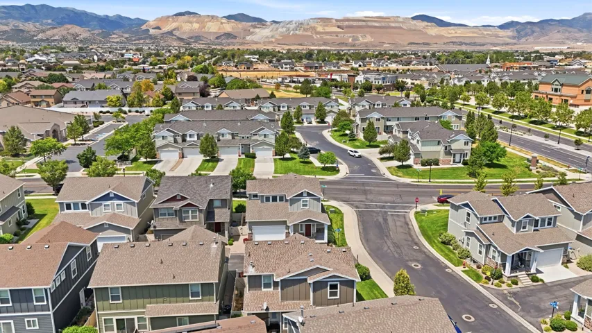 Residential neighborhood featuring a variety of single-family homes and townhomes, paved streets, and green landscaping