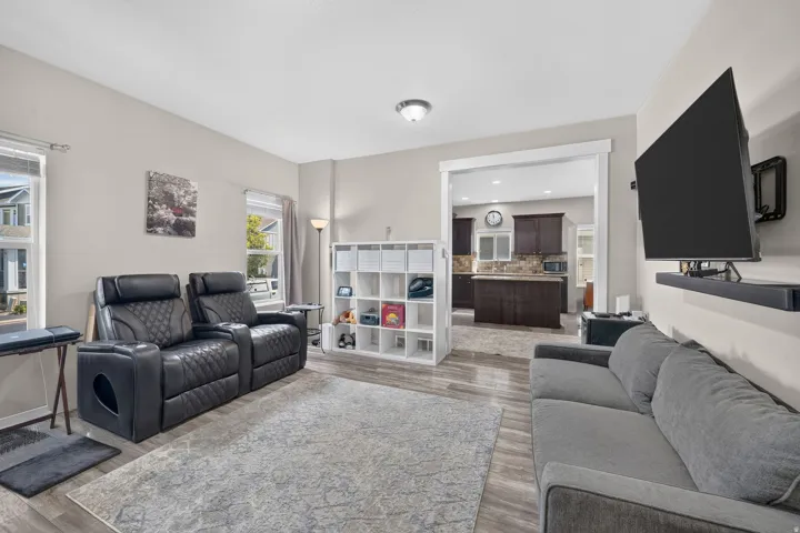 Open-concept living space featuring wood-finish flooring, light-toned walls, and white trim