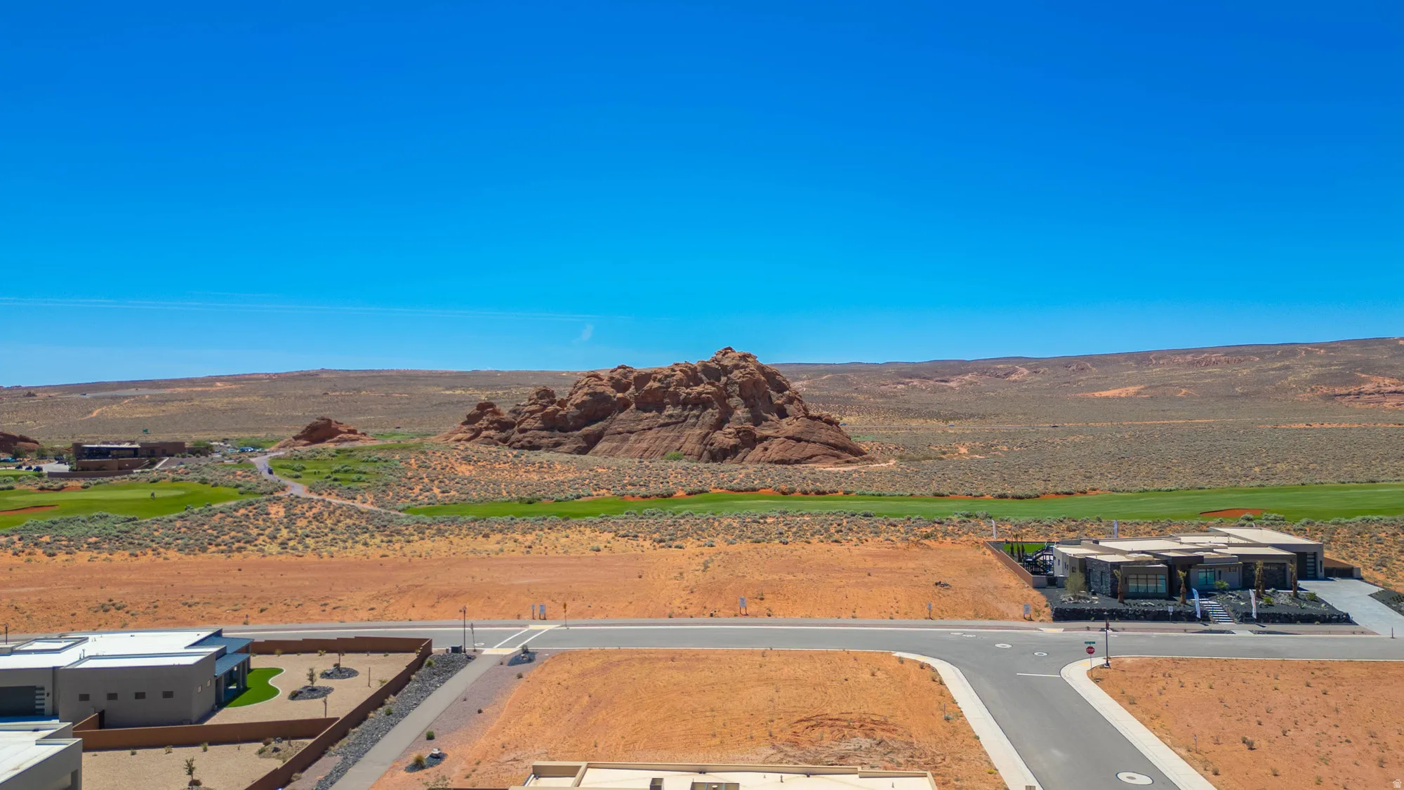 Modern desert community featuring a golf course, distinctive rock formations, and contemporary architecture
