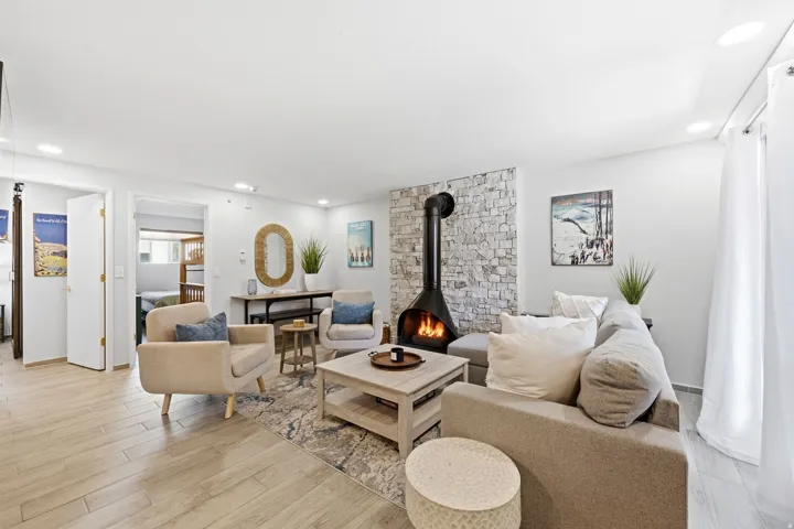 Living area featuring a floor-to-ceiling stone accent wall with a modern freestanding fireplace