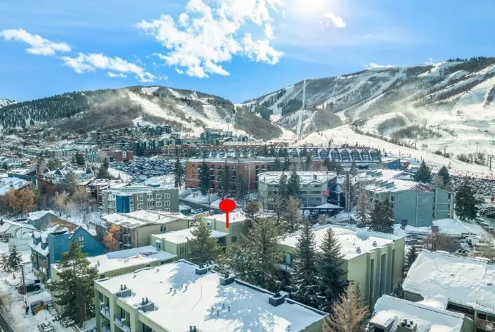 Aerial perspective showcasing a mountain resort town with snow-covered buildings and tree-lined streets