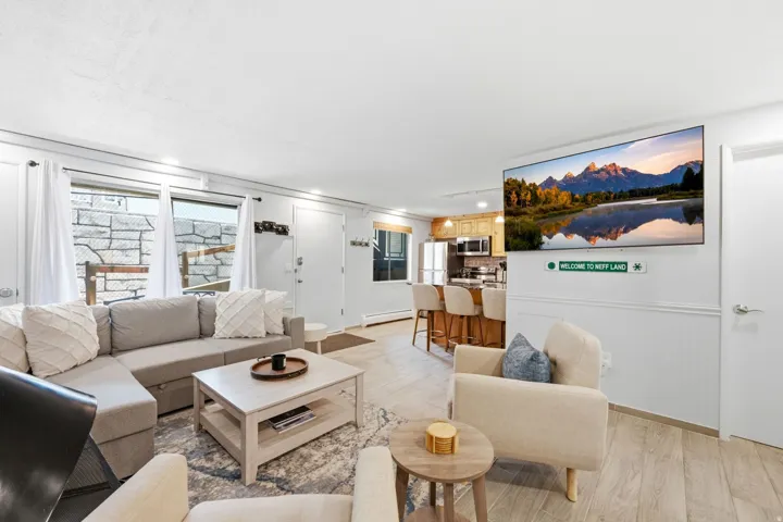 Open-concept living area featuring light wood-finish flooring, white shiplap wainscoting, and recessed lighting
