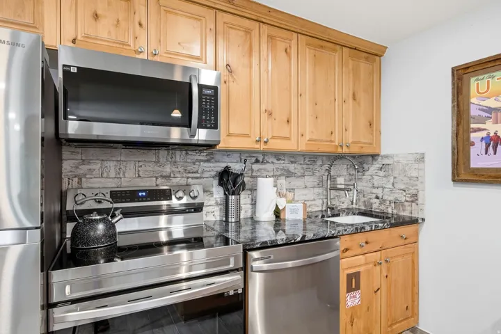 Kitchenette featuring a stainless steel refrigerator, microwave, electric range, and dishwasher
