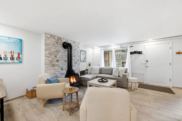 Living area featuring a modern freestanding fireplace with a stone-accented wall