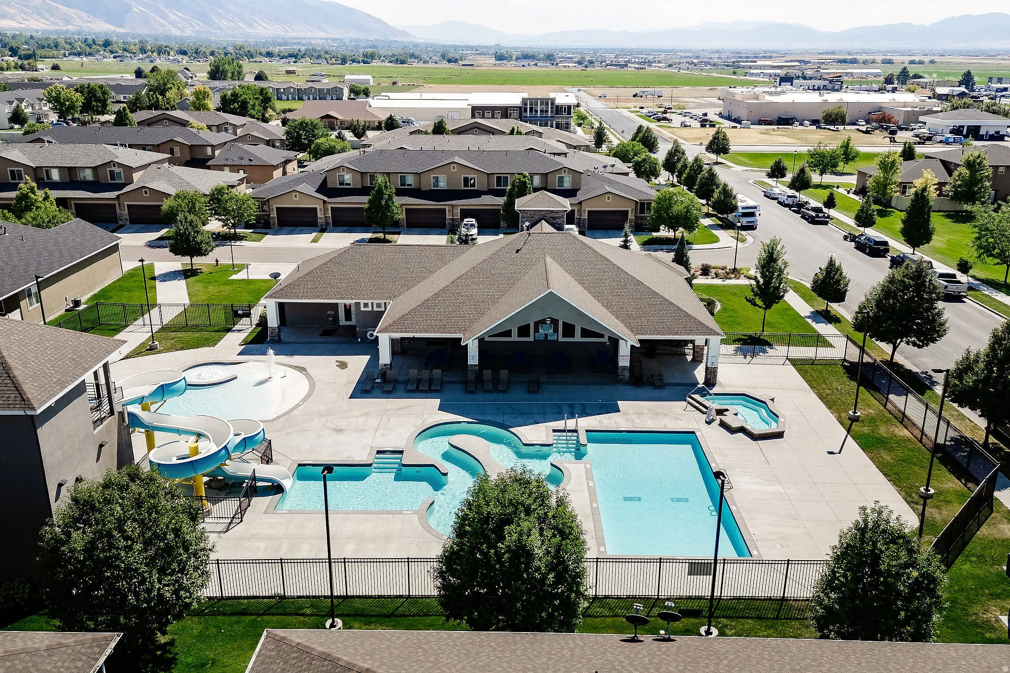 Community clubhouse featuring a covered patio, multiple swimming pools, and a separate hot tub