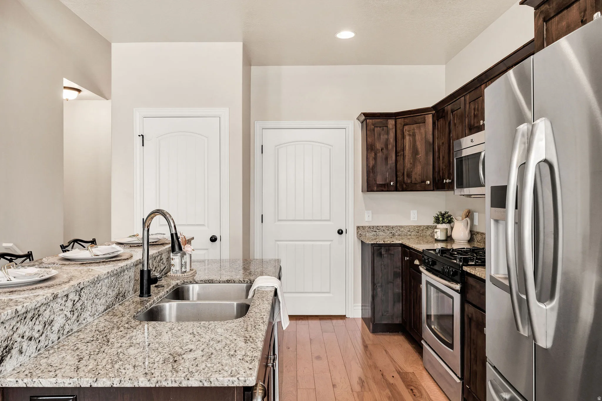 Kitchen featuring a two-tier granite island with a double basin sink and gooseneck faucet