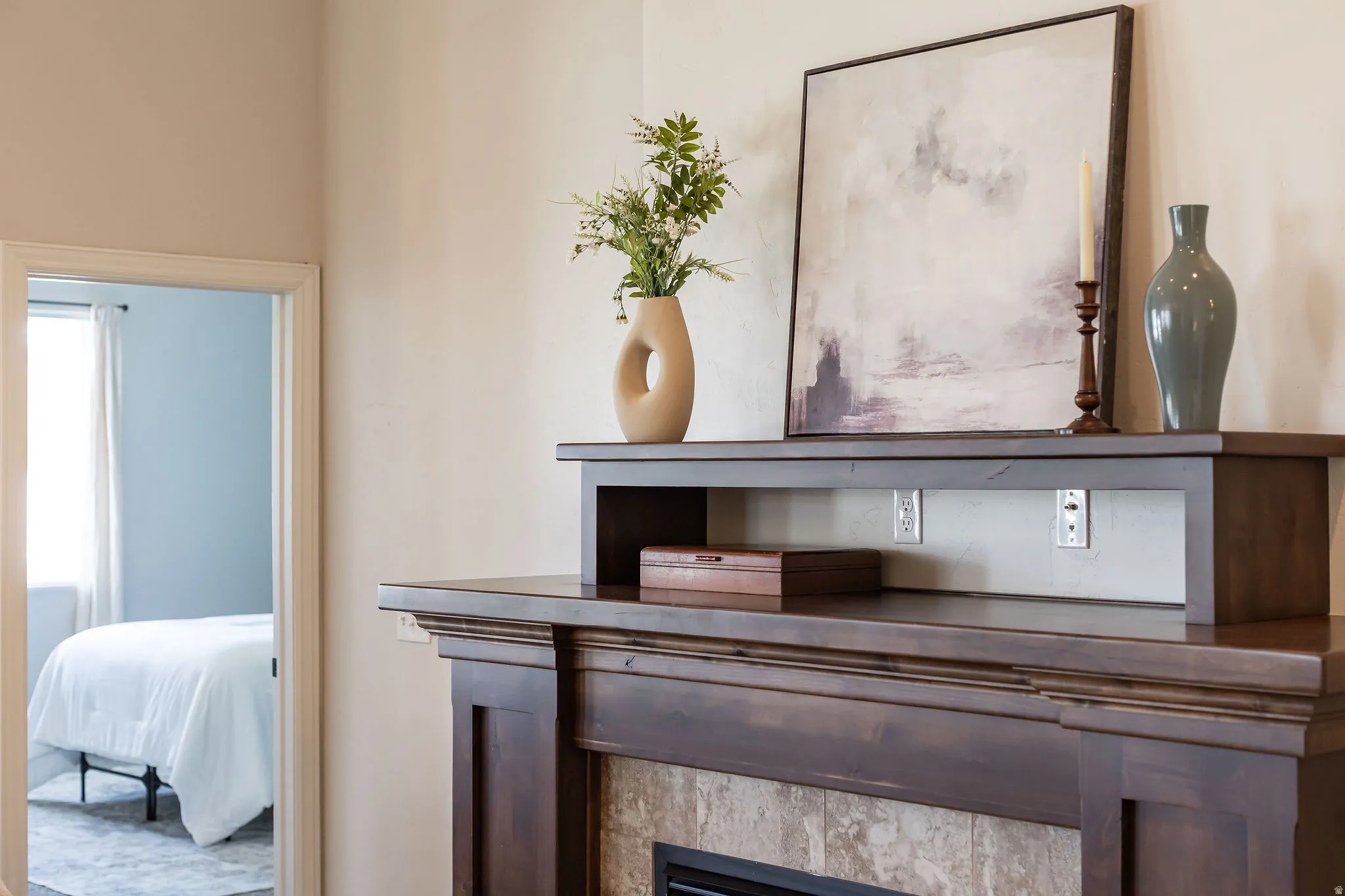 Dark wood-finish fireplace mantel with decorative corbels and a tiled surround