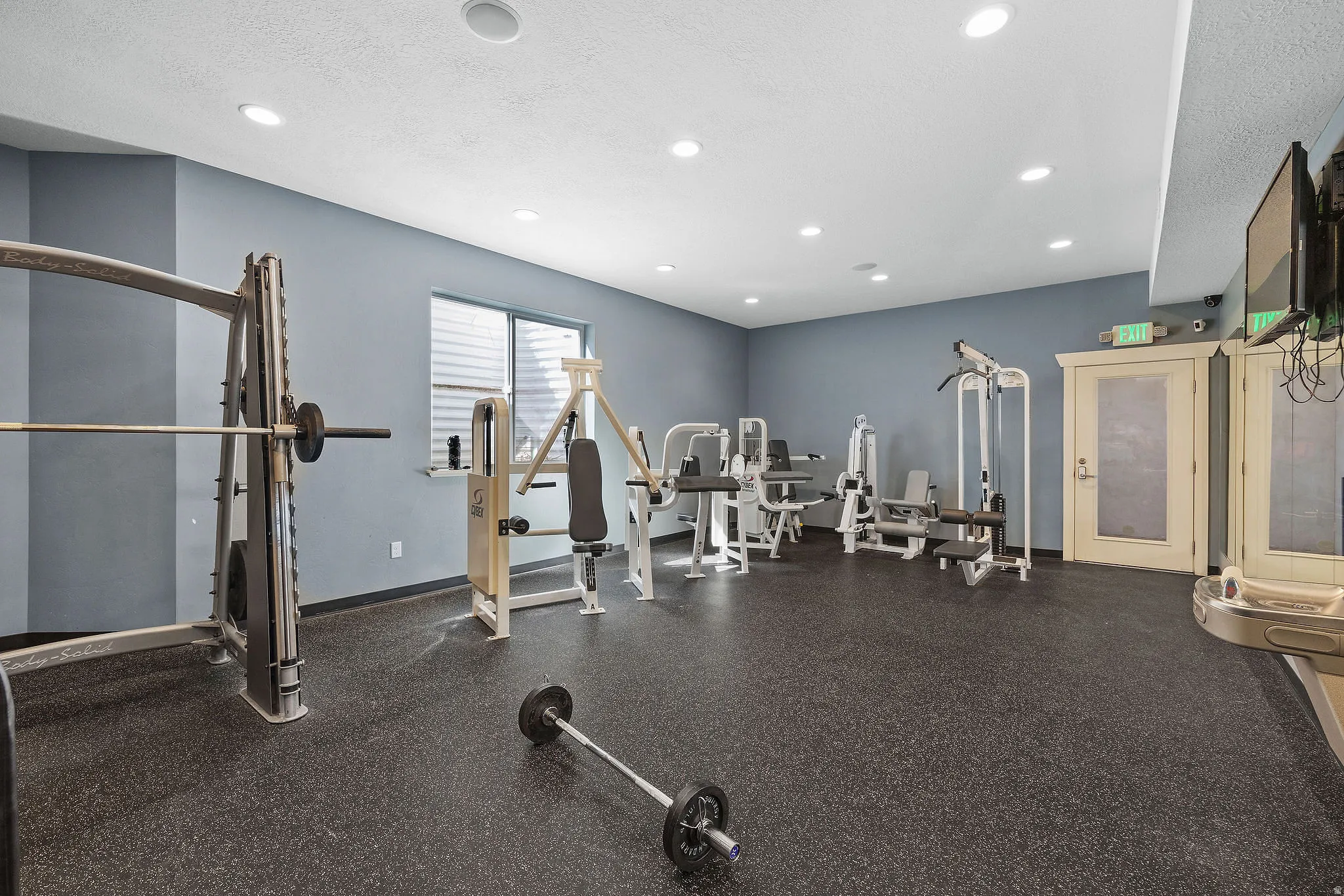 Fitness center featuring free weights, machine equipment and wall-mounted television