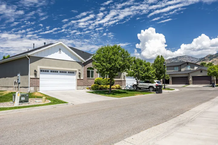 Contemporary residence featuring a two-car garage, stucco siding, and a brick facade accent