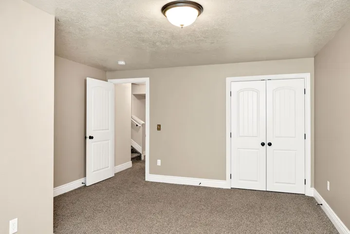 Carpeted interior space featuring neutral wall tones and white baseboards