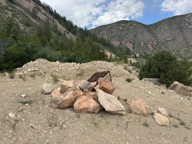 This random pile of rocks are going along with the grader not staying on the property.