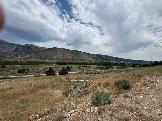 Expansive open land with natural desert vegetation and distant mountain ranges