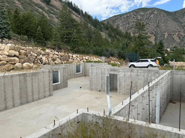 Concrete foundation with multiple interior walls and two visible egress window wells