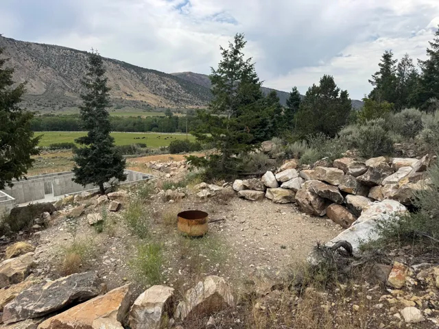 Terraced hillside lot featuring natural rock formations and a partial concrete foundation