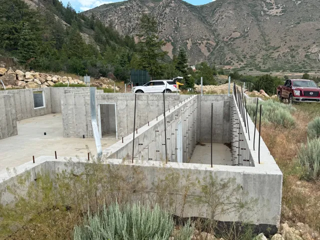 Concrete foundation walls with multiple framed openings, steel rebar, and a visible window well