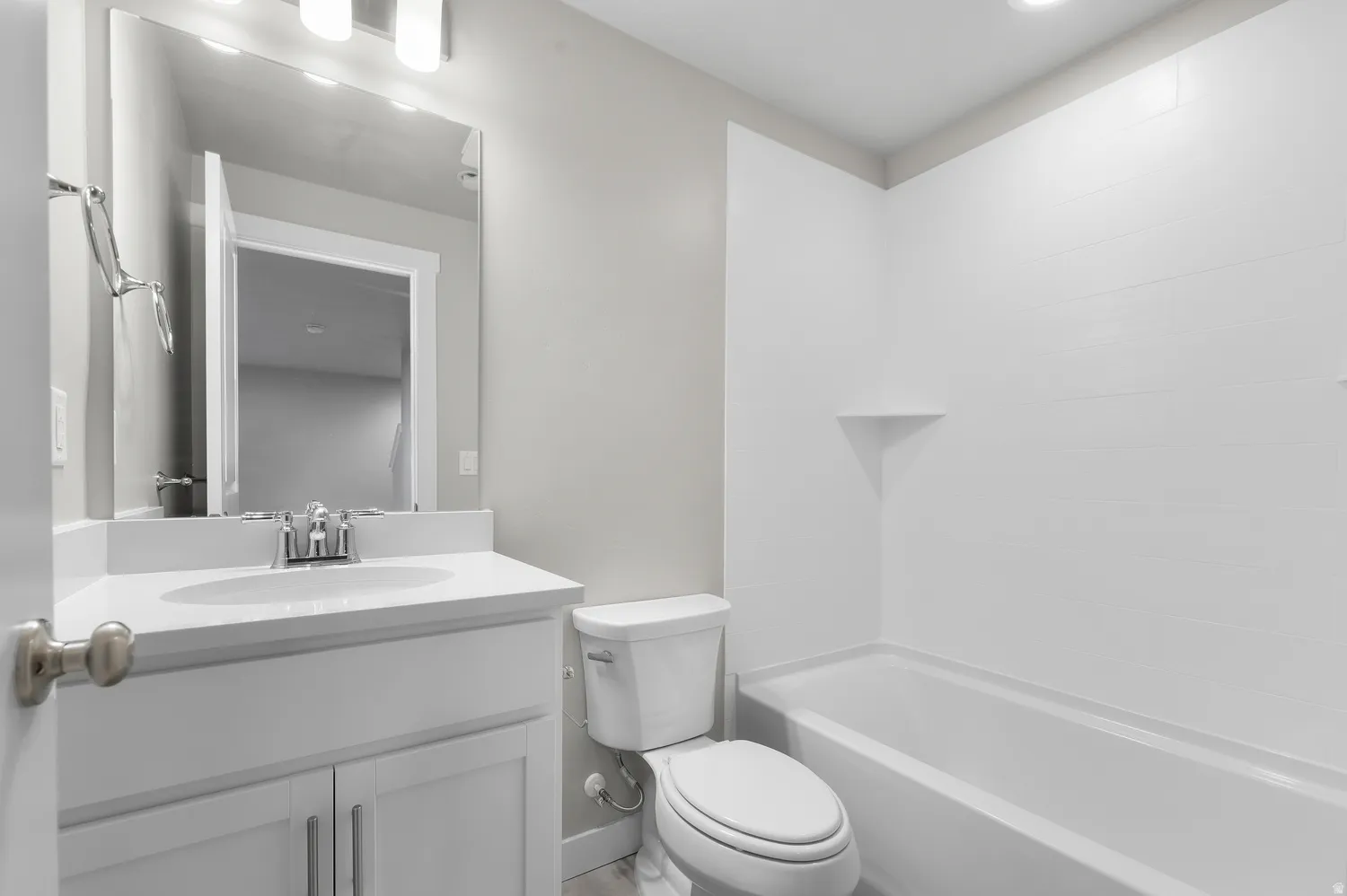 White vanity with a single basin sink, chrome faucet, and rectangular mirror