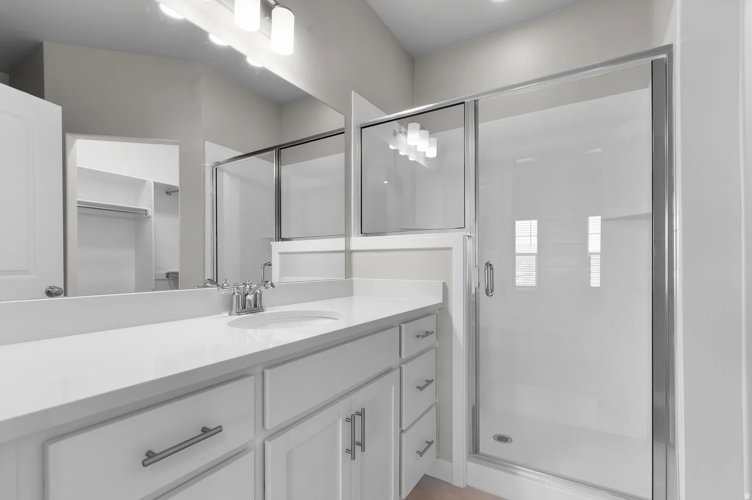White vanity with dual sinks, chrome fixtures, and a spacious countertop