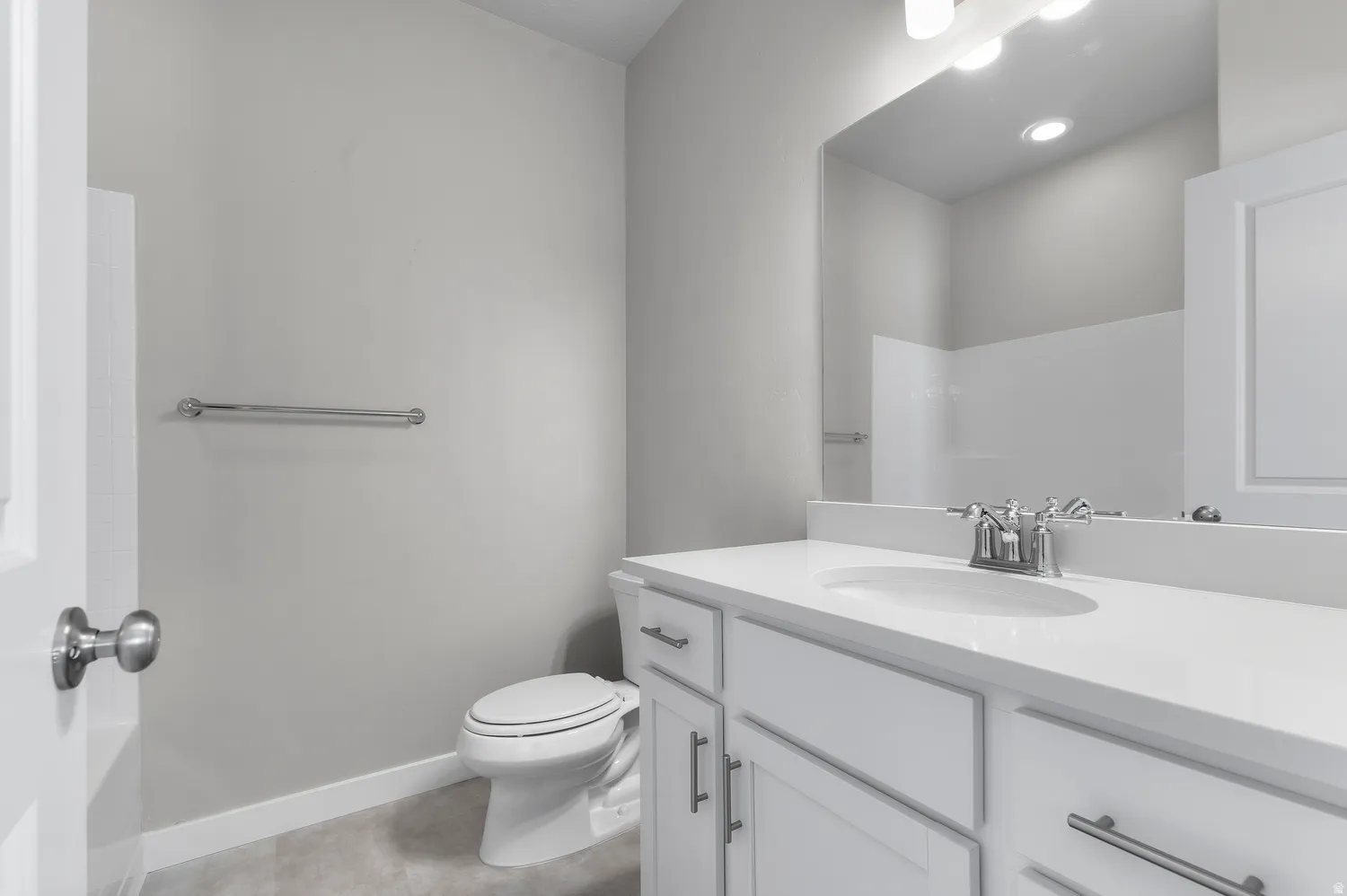 White vanity with shaker-style cabinetry, a white countertop, and an undermount sink with chrome fixtures