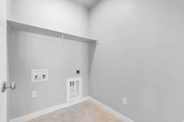Utility room featuring neutral wall color, overhead shelving, and carpet flooring