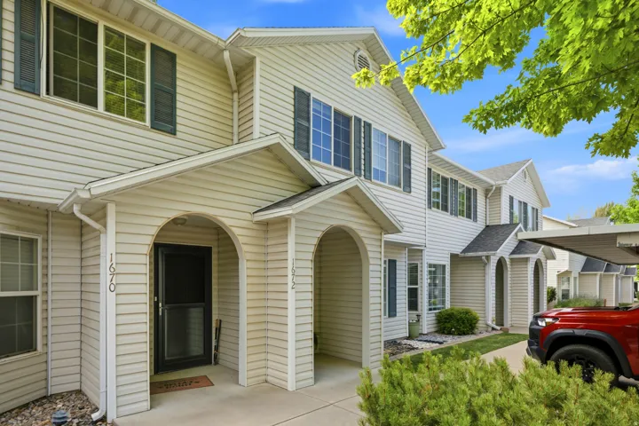White vinyl siding exterior with dark shutters