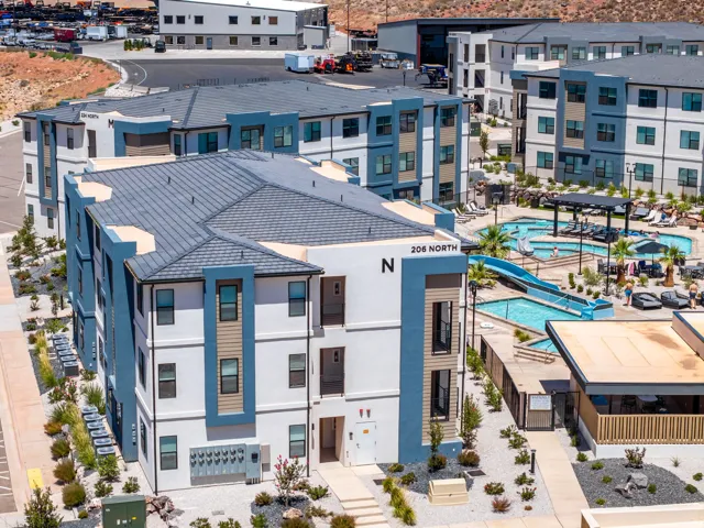 Contemporary multi-story building featuring a white and blue exterior with tan siding accents