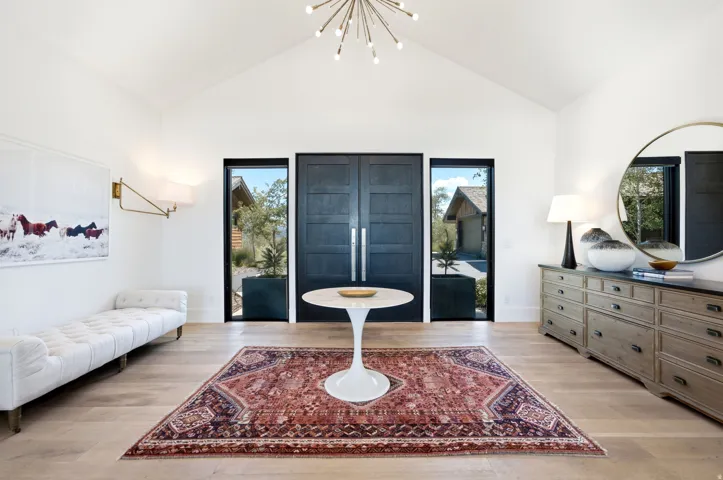 Vaulted ceiling entry featuring natural wood-finish flooring