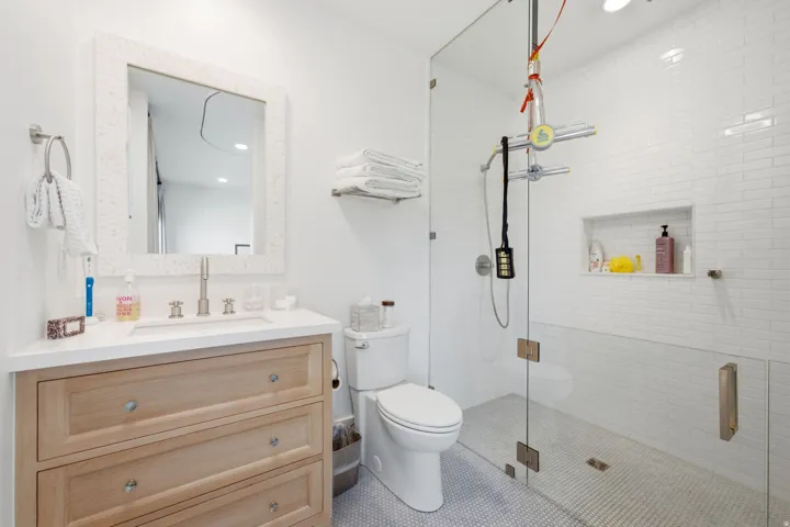 Modern bathroom featuring a glass-enclosed shower with subway tile surround and integrated niche