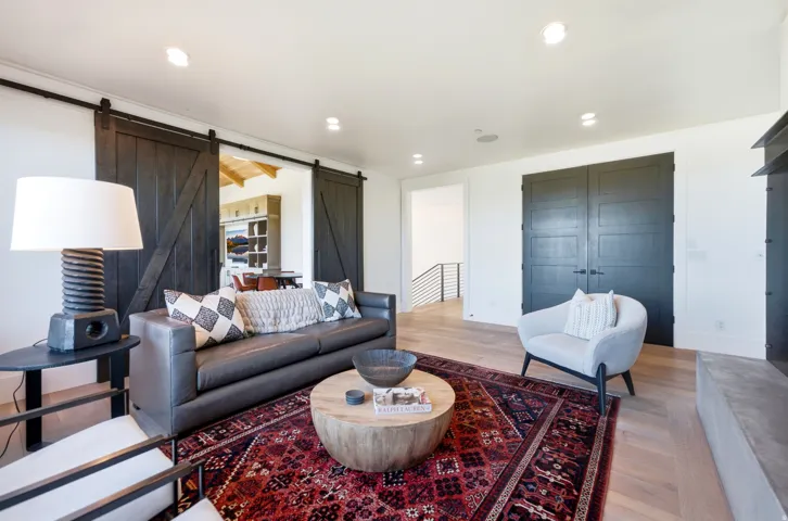 Living area with wood-finish flooring, recessed lighting, and a modern fireplace