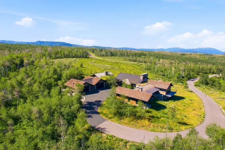 Sprawling property featuring multiple structures with natural wood siding and stone accents