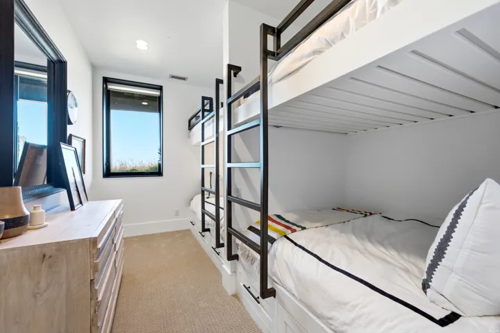 Built-in bunk beds with integrated drawers and metal ladders