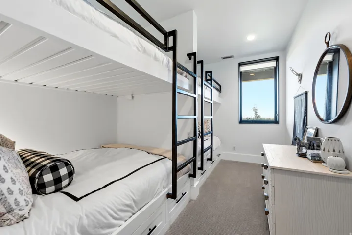 Built-in bunk beds featuring black metal frames and integrated storage drawers