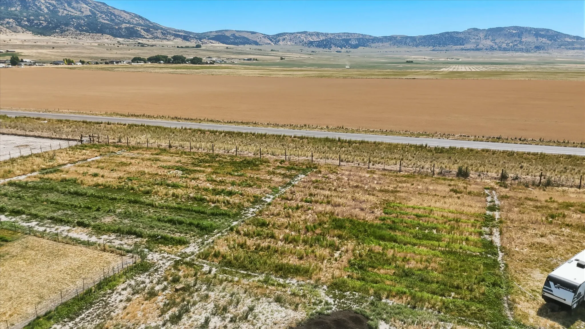 Expansive land parcel featuring open fields, distant mountains, and a clear horizon