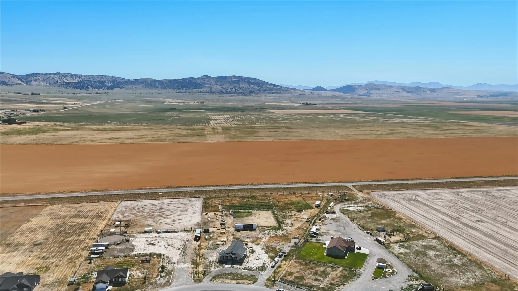 Expansive agricultural land extending towards distant mountains under a clear sky