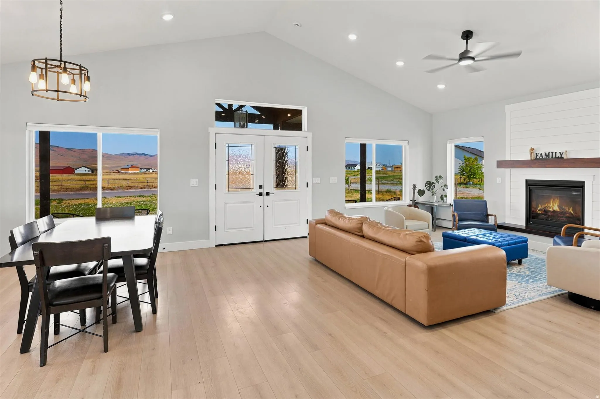 Open-concept living space featuring vaulted ceilings, light wood-finish flooring, and recessed lighting