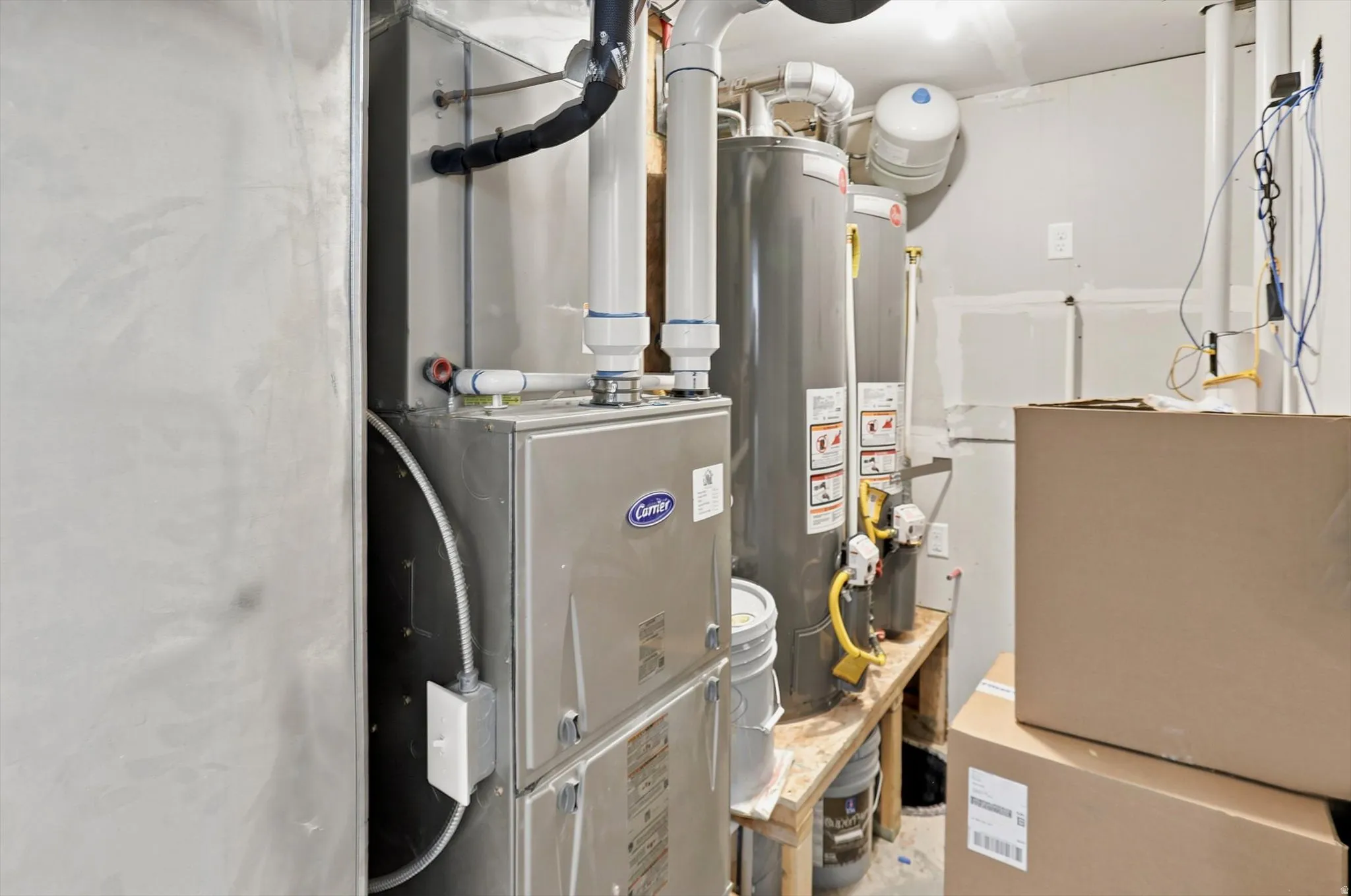 Utility area featuring a Carrier furnace system and two water heaters